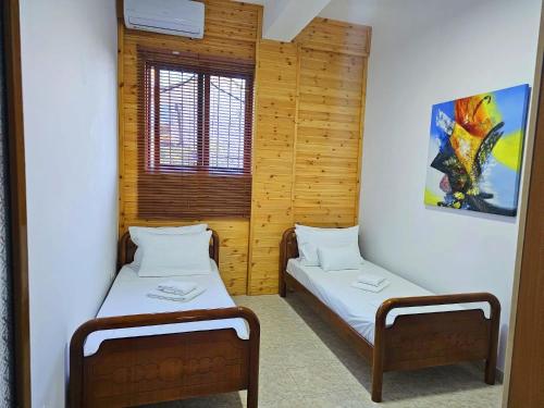 a room with two beds and a window at Homestay Beauty Day in Durrës