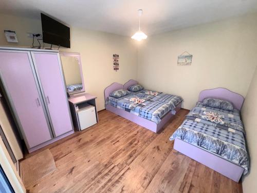 a bedroom with two beds and a television in it at Villa SUN in Kiten