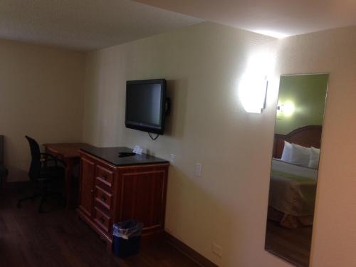 a hotel room with a bed and a desk and a television at Red Carpet Inn - New Brunswick in New Brunswick