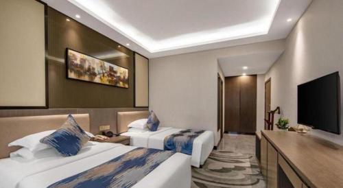 a hotel room with two beds and a flat screen tv at Shaanxi Business Hotel in Shanghai