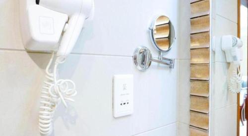 a bathroom with a phone and a mirror on the wall at Shaanxi Business Hotel in Shanghai