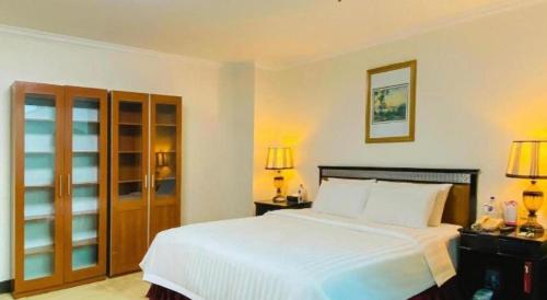 a bedroom with a large white bed and two lamps at Changchun Zhuozhan Days Hotel in Changchun