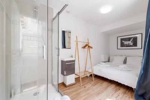 Cette chambre comprend un lit et une salle de bains pourvue d'une douche. dans l'établissement Charlotte by Terry's Homes, à Cannes