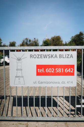 a sign on a metal fence with a sign on it at Rozewska Bliza Domki Letniskowe in Jastrzębia Góra