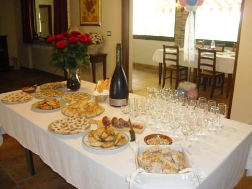 a table with plates of food and wine glasses at Rosso Di Sera in Novello
