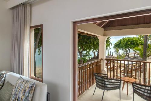 a porch with chairs and a table on a balcony at Hilton Mauritius Resort & Spa in Flic-en-Flac