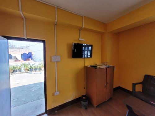 a room with a door and a tv on the wall at Hotel Bhardwaj in Namchi