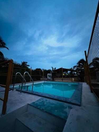 una piscina por la noche con una valla en Sevrina Beach INN, en Calangute