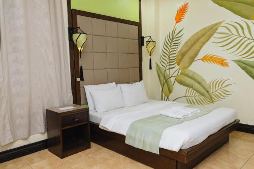 a bedroom with a bed with a tropical mural on the wall at La Traviesa Hotel Resort in General Trias