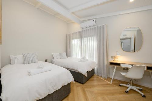 a bedroom with two beds and a desk and a mirror at San Lameer Villa 2027 - 2 Bedroom Superior - 4 pax - San Lameer Rental Agency in Southbroom