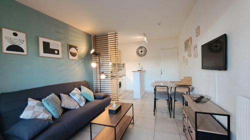 un salon avec un canapé et une salle à manger dans l'établissement Appartement avec Piscine, Quartier calme proche centre et plages d'Antibes, à Antibes