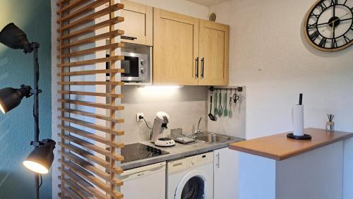 une petite cuisine avec un évier et un micro-ondes dans l'établissement Appartement avec Piscine, Quartier calme proche centre et plages d'Antibes, à Antibes