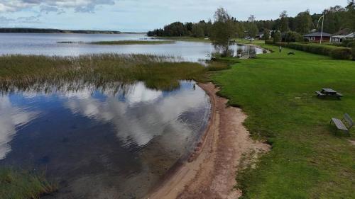 Blick auf einen Wasserkörper mit einer Bank in der Unterkunft Charmigt Villa bredvid sjön Örlen in Tibro