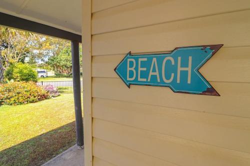 a beach sign on the side of a house at Beachside Cottage at Blacksmiths in Blacksmiths