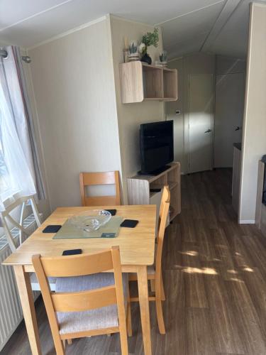 a dining room table and chairs in a living room at Singh&Leite Family caravan for 10 people with 2toilets and lovely Decking in Jaywick Sands