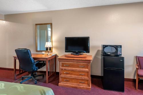 a hotel room with a television and a desk with a chair at Quality Inn Grand Junction near University in Grand Junction