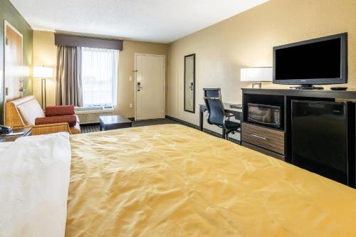a hotel room with a large bed and a flat screen tv at Quality Inn Perry - National Fairgrounds Area in Perry