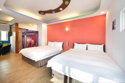 two beds in a room with red walls at Kenting 166 in Kenting