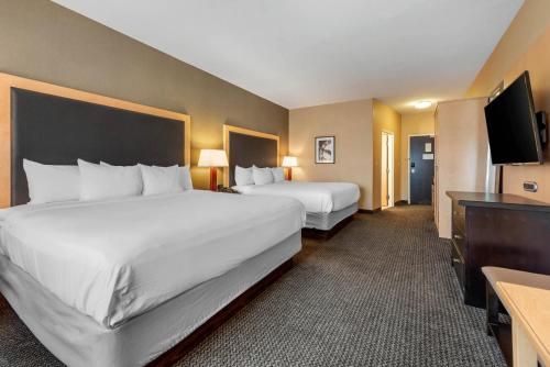 a hotel room with two beds and a flat screen tv at Cambria Hotel Akron - Canton Airport in Uniontown