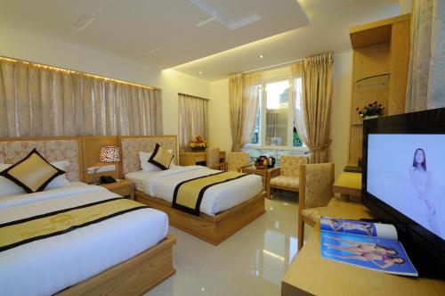 Habitación de hotel con 2 camas y TV de pantalla plana. en Vuong Tai Hotel, en Ho Chi Minh