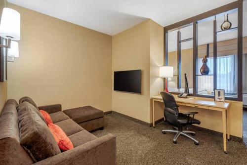 a living room with a couch and a desk with a computer at Cambria Hotel Akron - Canton Airport in Uniontown