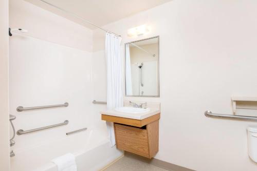 a bathroom with a sink and a mirror at WoodSpring Suites Columbus near Fort Benning in Columbus