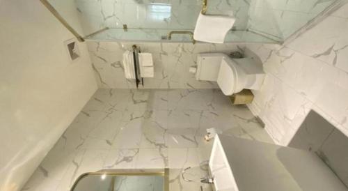 a white bathroom with a toilet and a sink at Beijing Inner Mongolia Hotel Chaoyang in Beijing