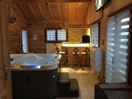 a bathroom with a tub and a sink in a room at Chalet de la Roche Gauthier in Gérardmer