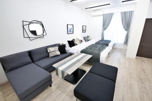 a living room with a couch and a bed at Oliver 502 in Tokyo