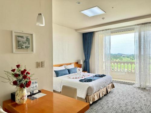 a hotel room with a bed and a window at Sono Belle Haiphong in Hai Phong