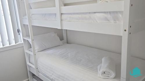 a white bunk bed in a white room at 2B at Swansea cosy cottage, outdoor pet friendly in Swansea