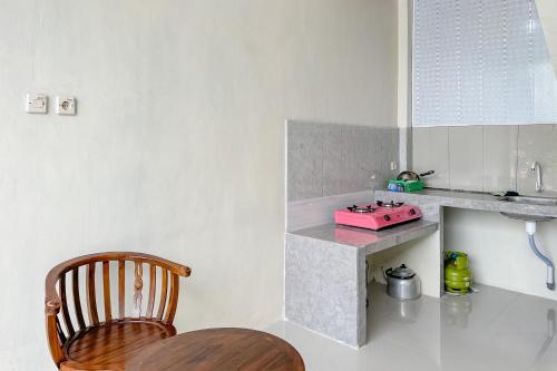 a kitchen with a counter and a wooden chair at RedDoorz Syariah Zidney Near Rejosari Salatiga in Salatiga