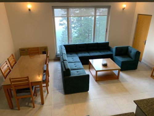 Khaira GaliPine Edge by T2R - Luxury Duplex Apartment Private Parking & Stunning Views in Khaira Gali near to Nathia Gali & Muree的带沙发和桌子的客厅