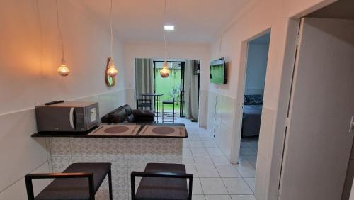una cucina con bancone, sedie e forno a microonde di W loft residence entire Apartamentos a Recife