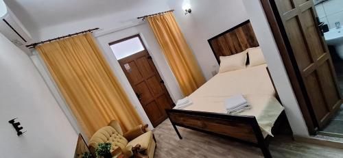a small room with a bed and a wooden door at Conac Bistreanu in Eforie Sud