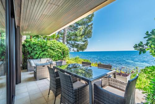 une terrasse avec une table et des chaises et l'océan dans l'établissement ADRIANA by Terry's Homes WATERFRONT SEAVIEW BEACH, à Cannes
