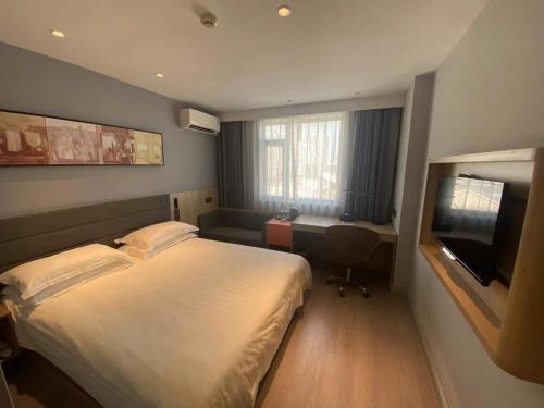 a bedroom with a bed and a desk and a television at Jinjiang Inn Wuhu High-Speed Railway Station West Square in Wuhu