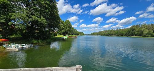 a river with boats parked on the side of it at Stacja Serwy - Dom z duszą in Serwy
