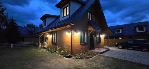a house with a car parked in front of it at Stacja Serwy - Dom z duszą in Serwy