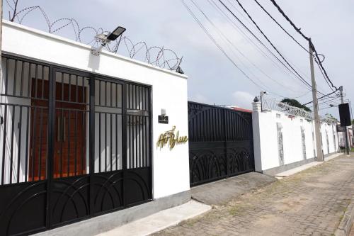 a white building with black gates on a street at AirBlue Villa in Ratmalana