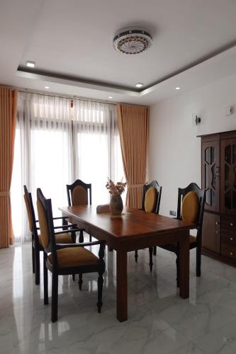 a dining room with a wooden table and chairs at AirBlue Villa in Ratmalana