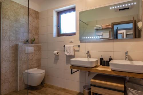 a bathroom with two sinks and a toilet at Villa Mediterranea, an idyllic new villa with a Mediterranean touch in Vinež