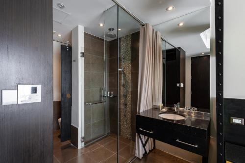 a bathroom with a sink and a glass shower at Siam@Siam Design Hotel Pattaya in Pattaya Central
