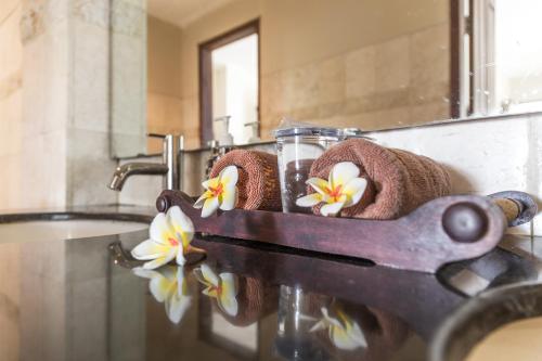 a bathroom with a sink with towels and a pair of scissors at Puri Wirata Dive Resort and Spa Amed in Amed