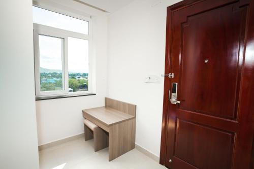 a bathroom with a wooden bench and a window at Blue Sky Phu Quoc Hotel in Phu Quoc