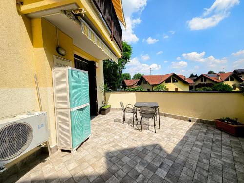 a patio with a table and chairs next to a house at Malpensa Retreat in Ferno