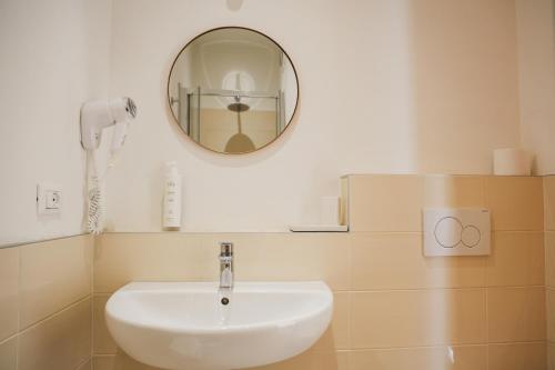a white sink in a bathroom with a mirror at Hotel Eden in Bardolino