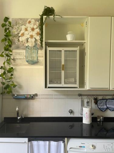 a kitchen with white cabinets and a black counter top at Il Sogno di Giorgio in Chiavari
