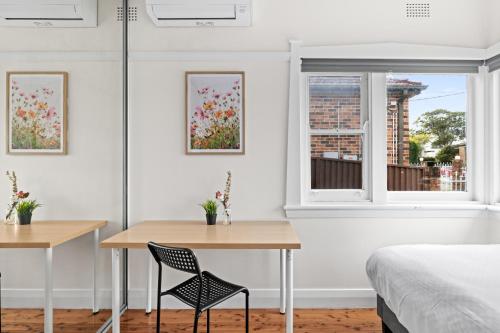a bedroom with a bed and two tables and a window at Budget-Friendly Comfort - Private Single Room in Padstow - Shared Bathroom in Padstow