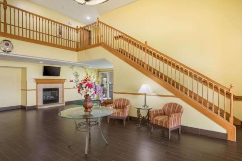 a living room with a staircase and a table with flowers at Quality Inn in Edgerton